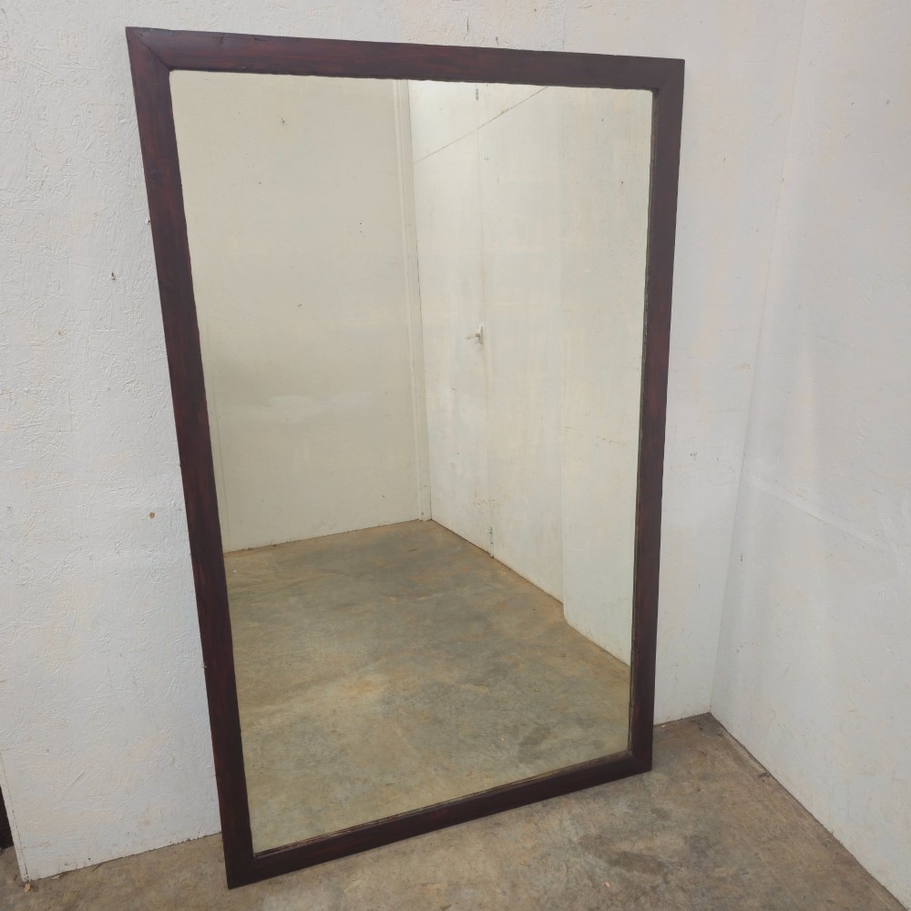 A large 19th-century rectangular full-length mirror with a dark-stained pine frame.