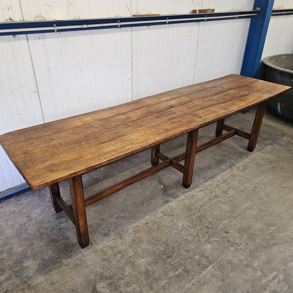 An extra long French beechwood table featuring a plank top, six square legs, and supporting stretchers in a warm brown timber finish. View IV