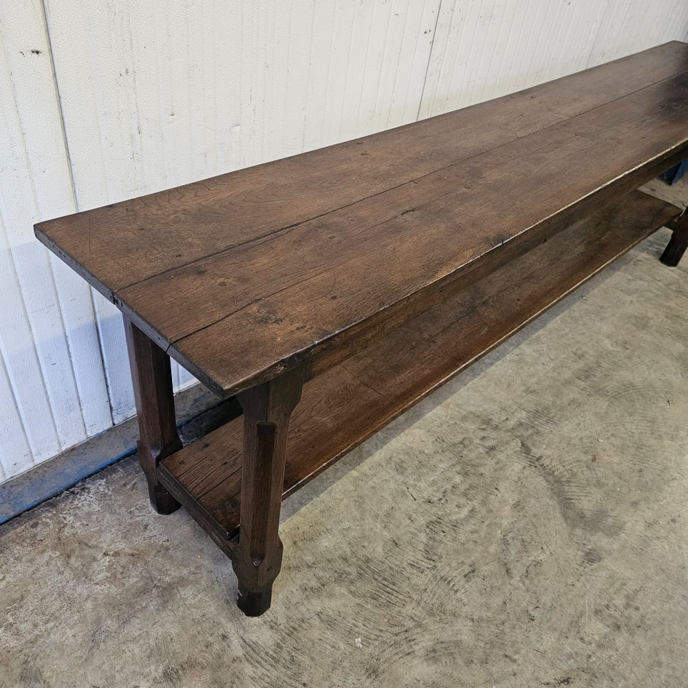 A long, narrow dark oak French serving table featuring a plank top, square legs, and a full-length lower pot shelf. View VI