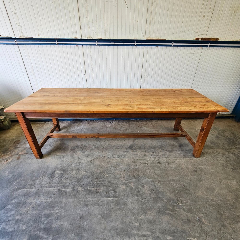 A long French country dining table crafted from beech and elm timber with a plank top and an H-stretcher base. View II