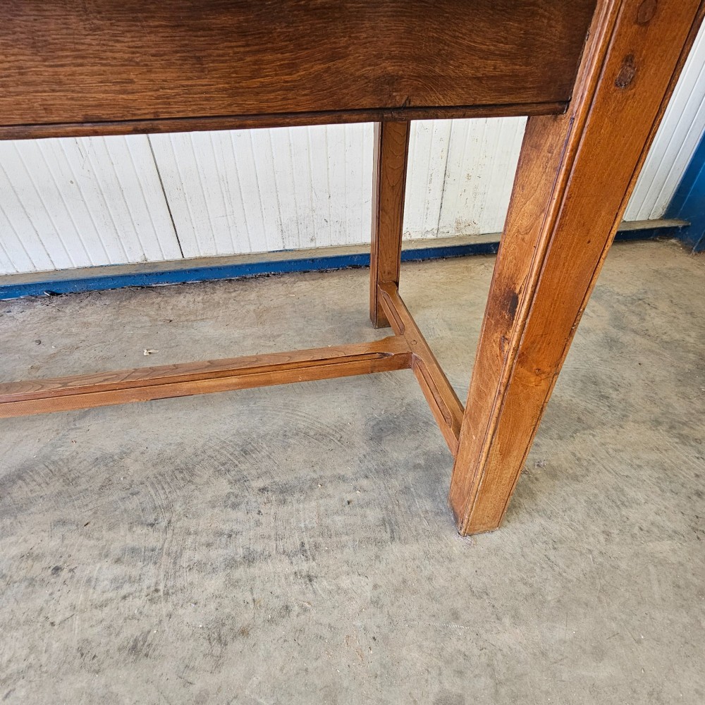 A long French country dining table crafted from beech and elm timber with a plank top and an H-stretcher base. View IV
