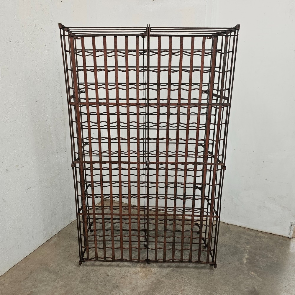 A large freestanding French steel wine rack featuring a open lattice riveted frame with multiple horizontal bottle tiers. View III