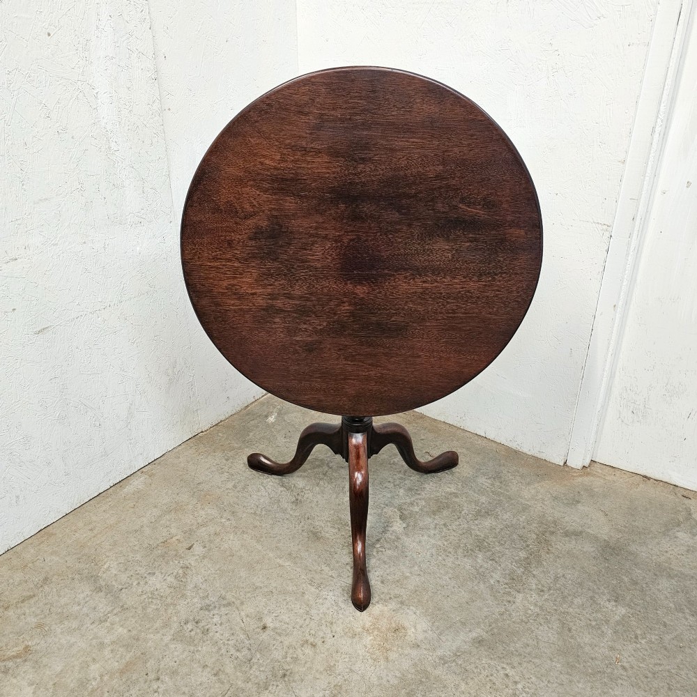 A Georgian dark mahogany wine table featuring a circular tilt-top surface supported by a turned baluster column and three cabriole tripod legs. View III