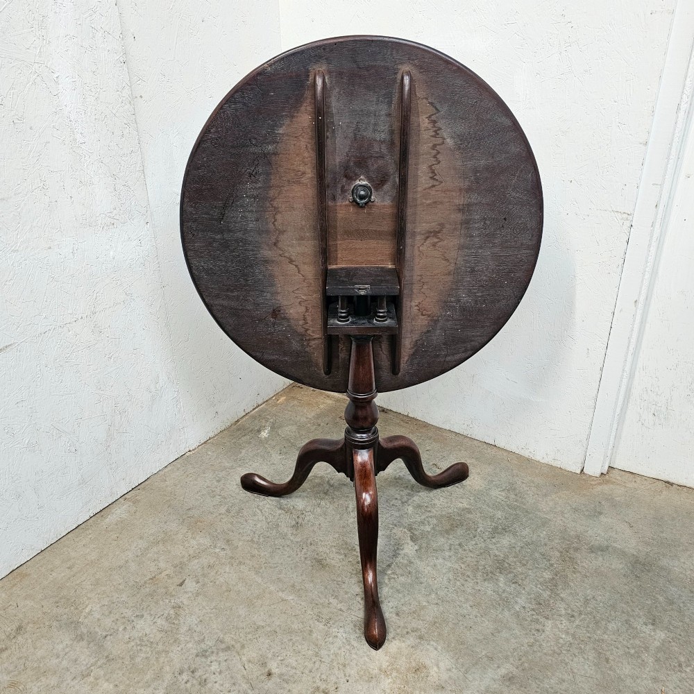 A Georgian dark mahogany wine table featuring a circular tilt-top surface supported by a turned baluster column and three cabriole tripod legs. View IV