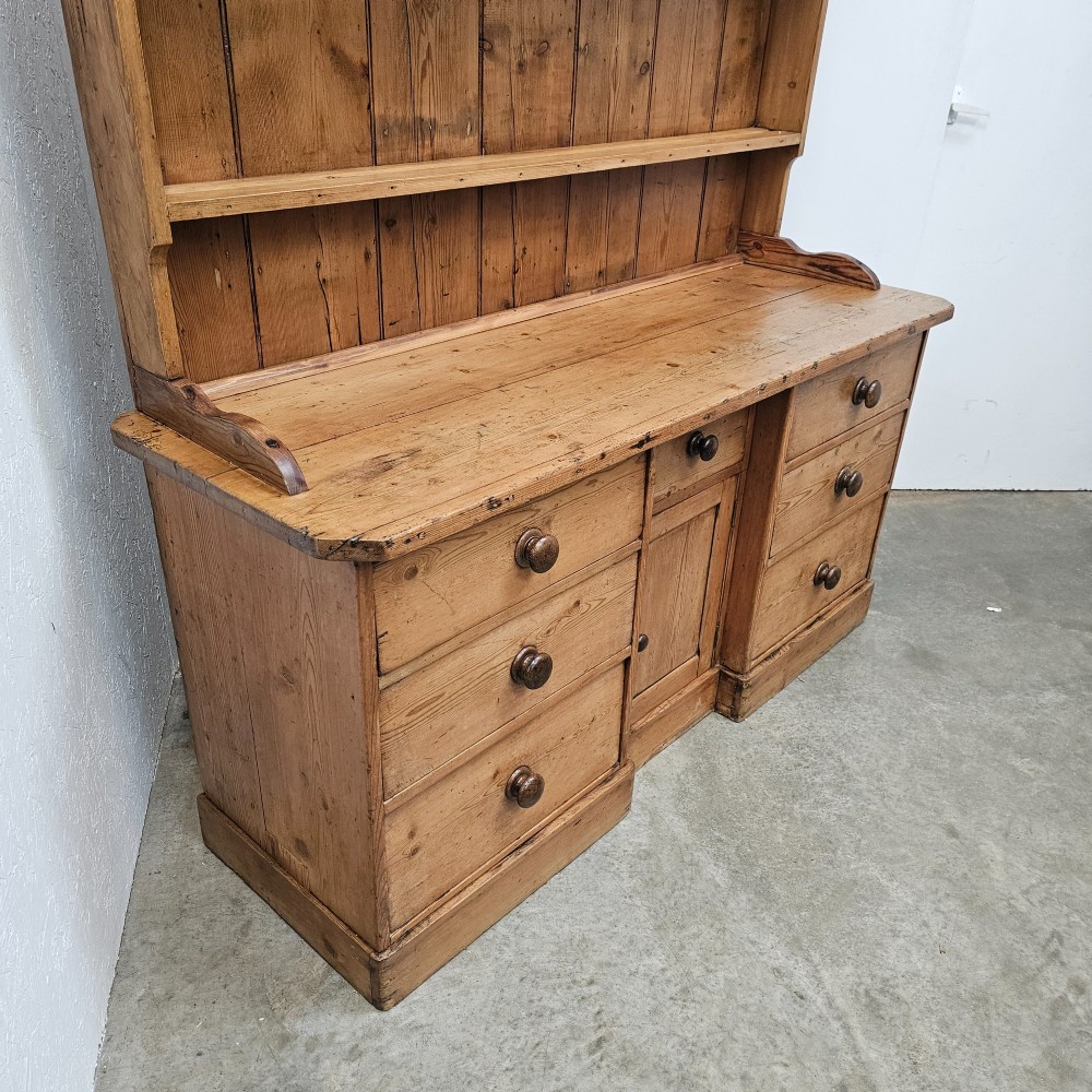A 19th-century English pine dresser featuring a three-tier open rack above a base unit with six drawers and a central cupboard door. View V