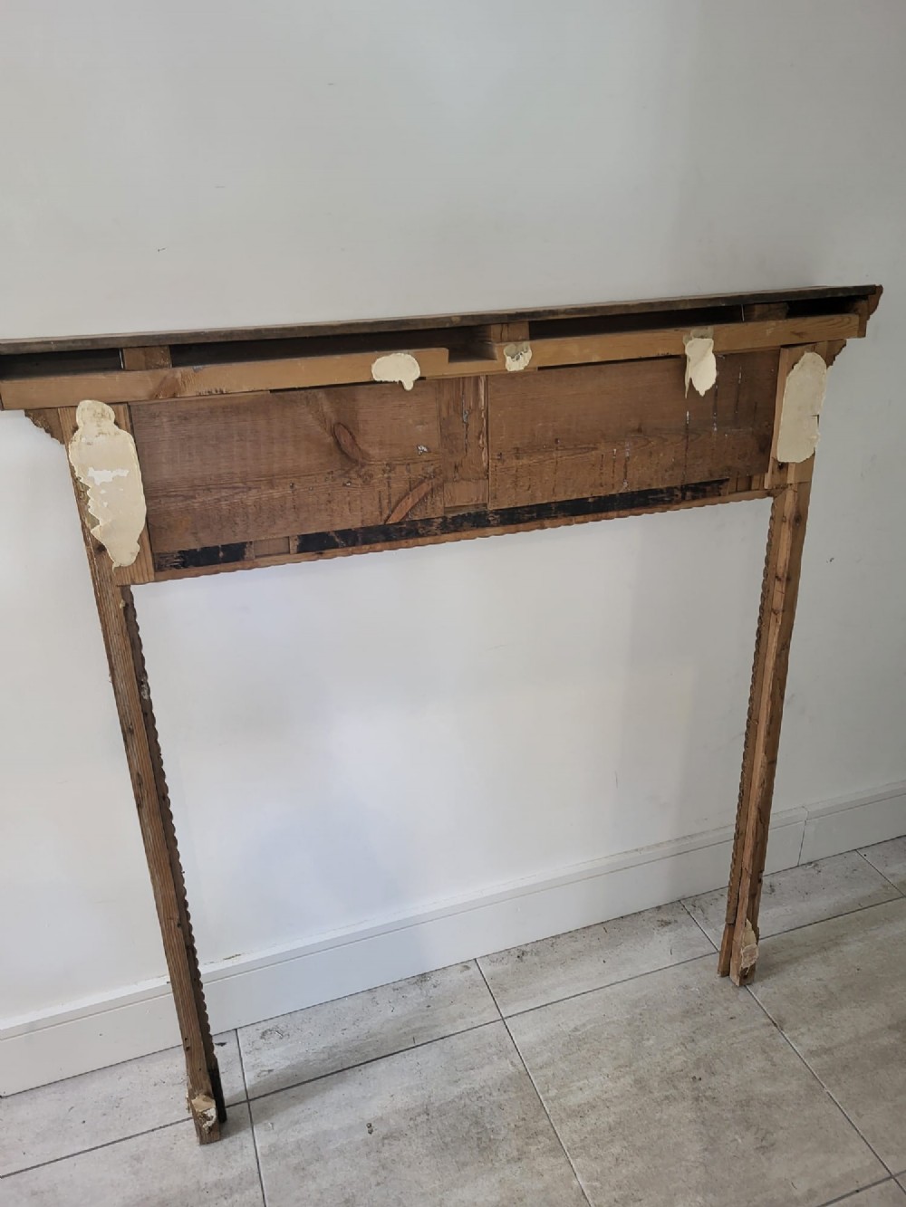 A Georgian pine fireplace surround featuring a wide mantel shelf, a vertically fluted frieze, and carved rope twist mouldings bordering the aperture. View VI