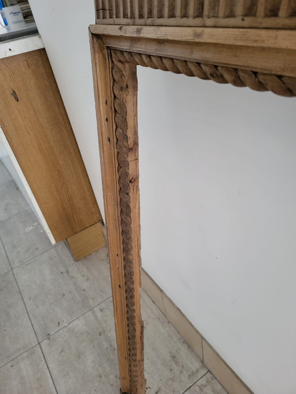 A Georgian pine fireplace surround featuring a wide mantel shelf, a vertically fluted frieze, and carved rope twist mouldings bordering the aperture. View VII