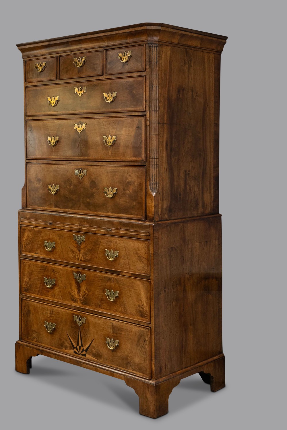 A two-section George II walnut chest-on-chest tallboy featuring brass handles, bracket feet, and a starburst inlay design on the lower drawer. View III