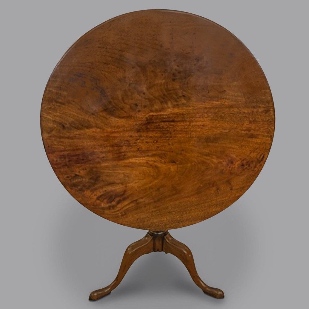 A George III mahogany tripod table featuring a circular top set on a central turned column with a spiral knop and three cabriole legs ending in pad feet. View II