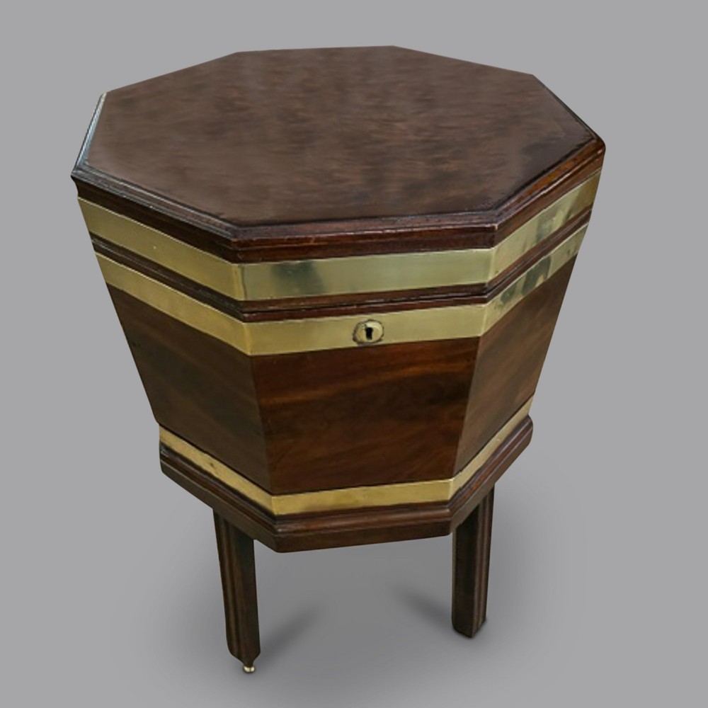 An 18th-century octagonal mahogany wine cooler featuring polished brass binding, a hinged lid with keyhole, and square moulded legs.