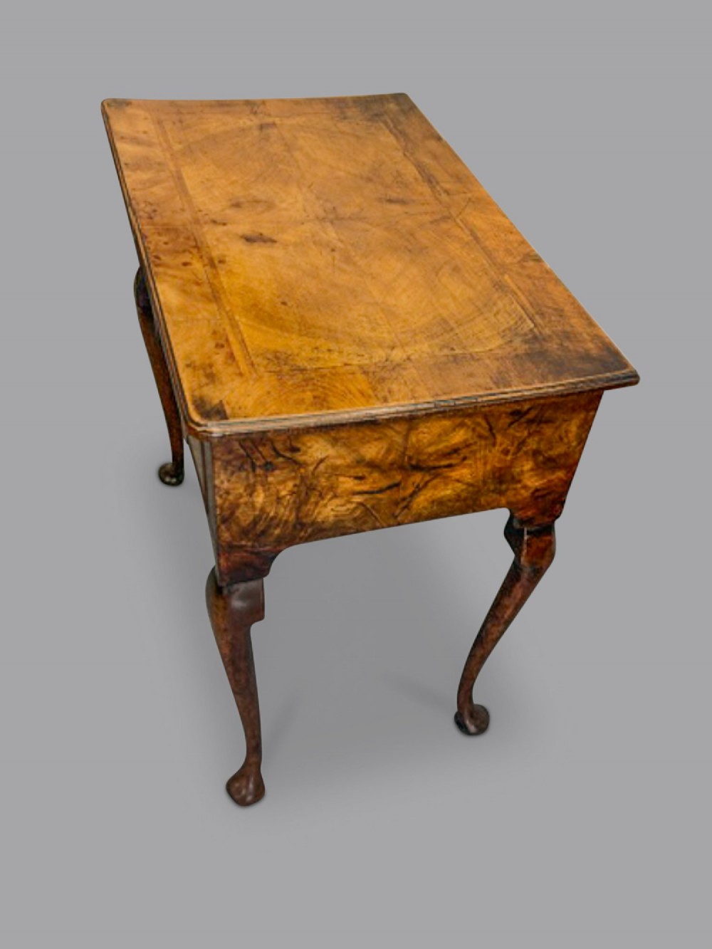 A George I walnut lowboy featuring three crossbanded drawers with brass drop ring handles, raised on four slender cabriole legs with pad feet. View II