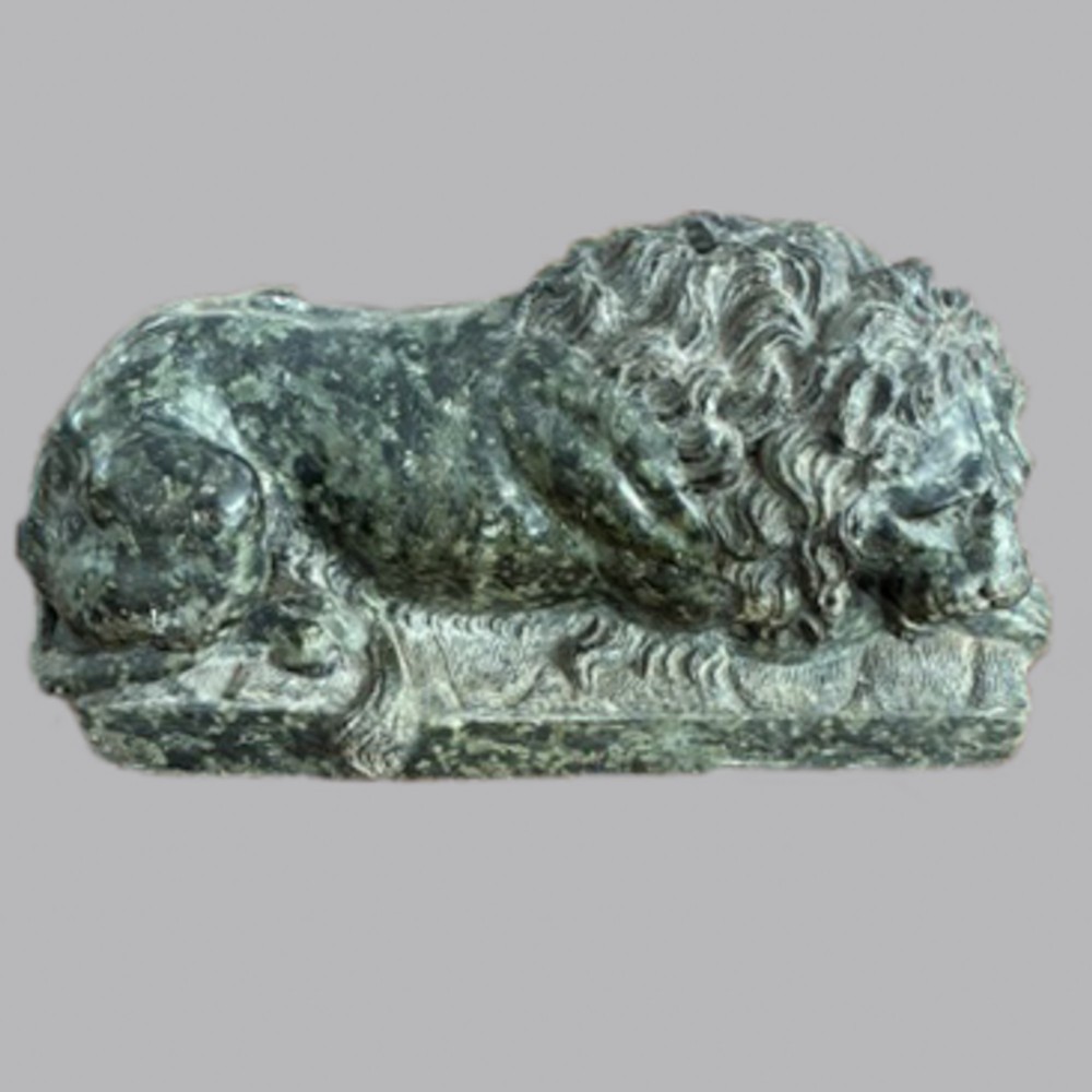 A 19th-century carved dark green marble sculpture depicting a recumbent lion lying on an integral rectangular stone base.
