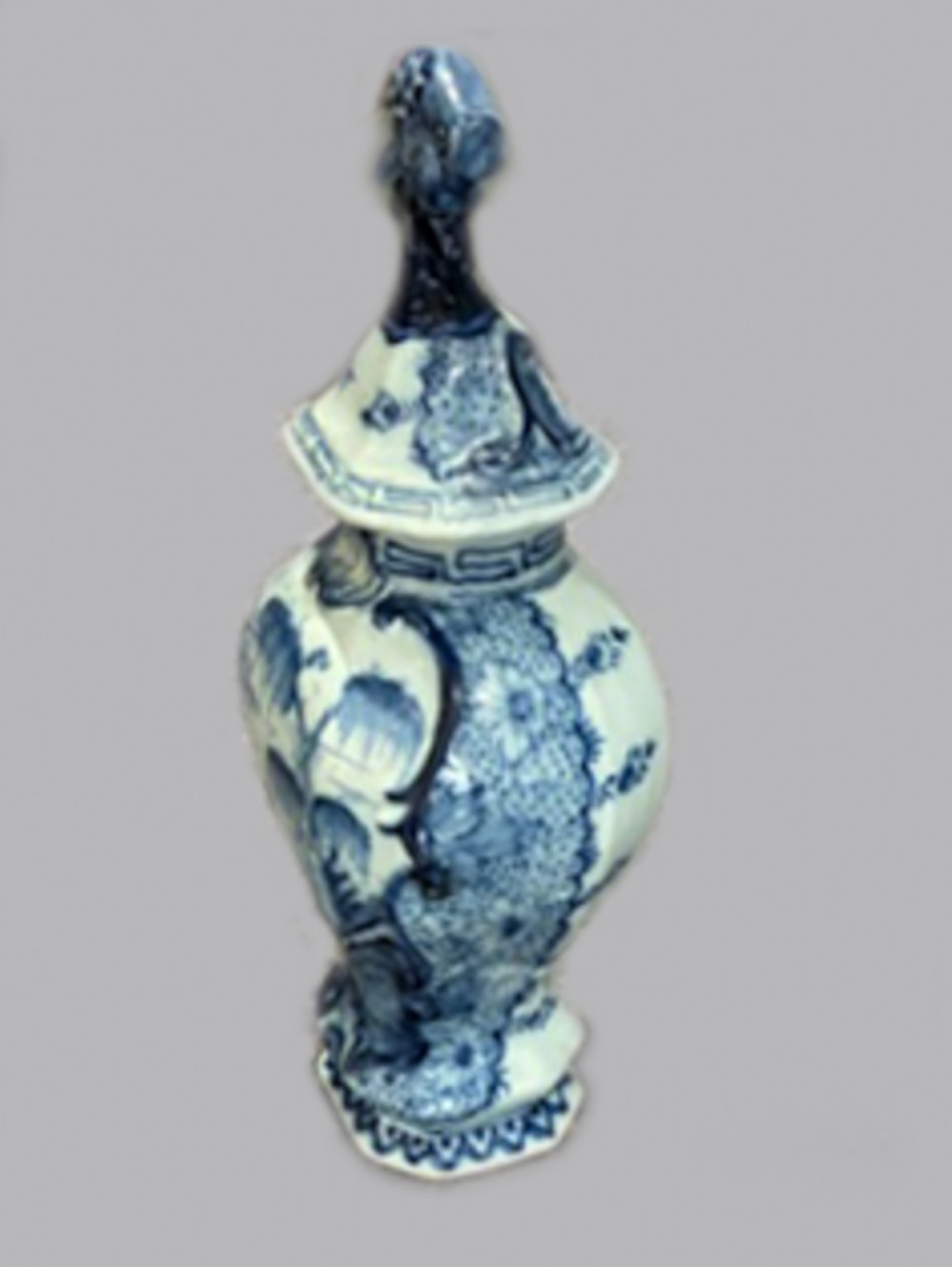 An 18th-century Dutch Delftware lidded vase decorated with blue and white hand-painted chinoiserie landscapes and topped with a sculpted bird finial. View II