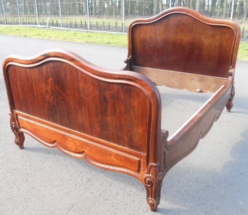 fig 1. An antique Victorian rosewood double bed frame featuring a shaped headboard, matching footboard, and carved feet.