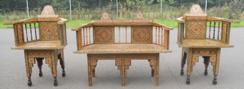 fig 1. A three-piece wooden seating suite comprising a settee and two matching armchairs adorned with geometric bone and mother-of-pearl inlay.