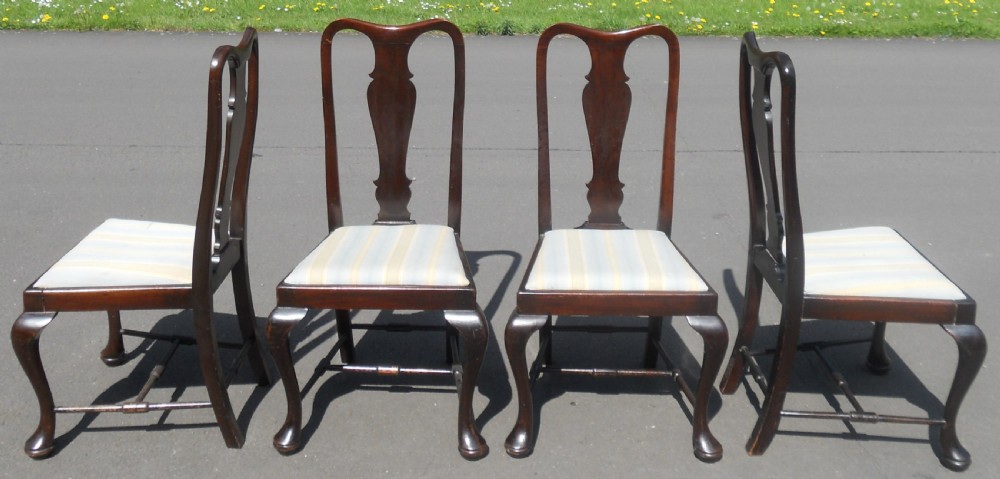 A set of four dark mahogany highback dining chairs featuring vase-shaped splats, cabriole legs, and striped upholstered drop-in seats. View IV
