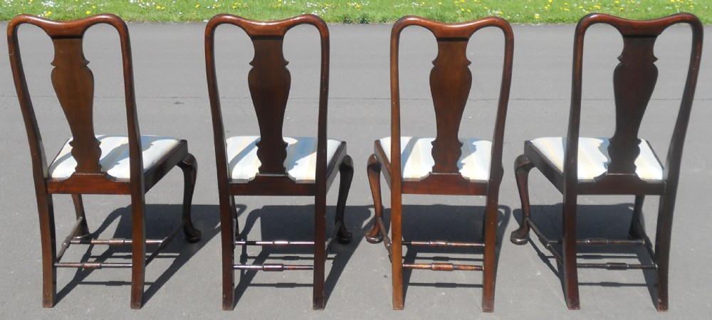 A set of four dark mahogany highback dining chairs featuring vase-shaped splats, cabriole legs, and striped upholstered drop-in seats. View V