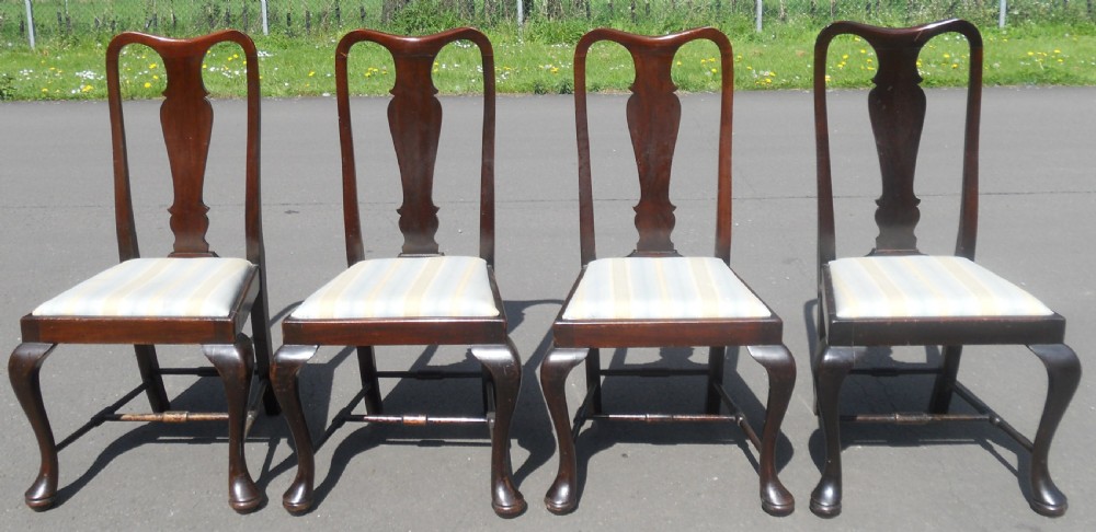 A set of four dark mahogany highback dining chairs featuring vase-shaped splats, cabriole legs, and striped upholstered drop-in seats. View VI