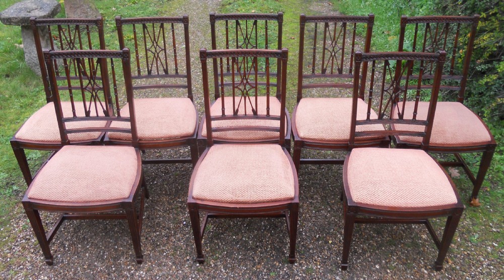 A set of eight dark mahogany dining chairs featuring carved lattice backs, square tapered legs, and peach fabric upholstered seats. View II