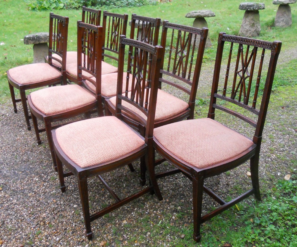 A set of eight dark mahogany dining chairs featuring carved lattice backs, square tapered legs, and peach fabric upholstered seats. View IV