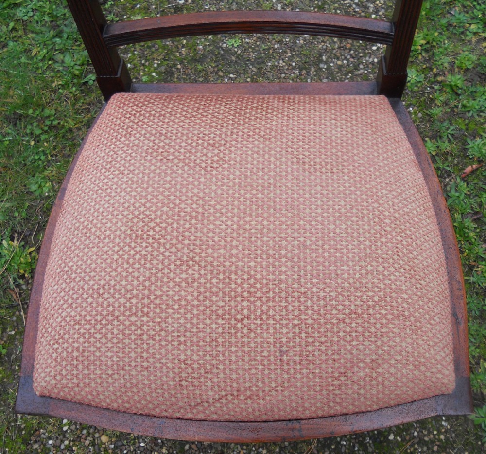 A set of eight dark mahogany dining chairs featuring carved lattice backs, square tapered legs, and peach fabric upholstered seats. View VII