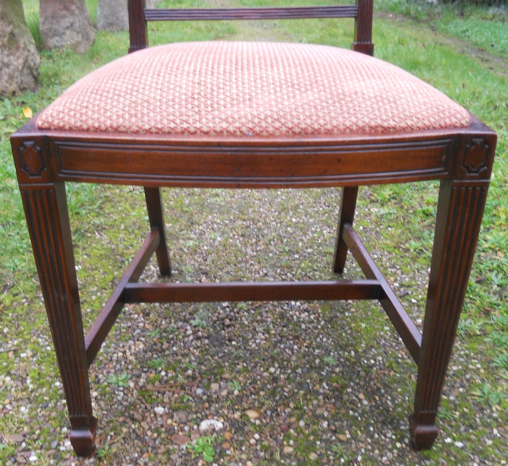 A set of eight dark mahogany dining chairs featuring carved lattice backs, square tapered legs, and peach fabric upholstered seats. View X