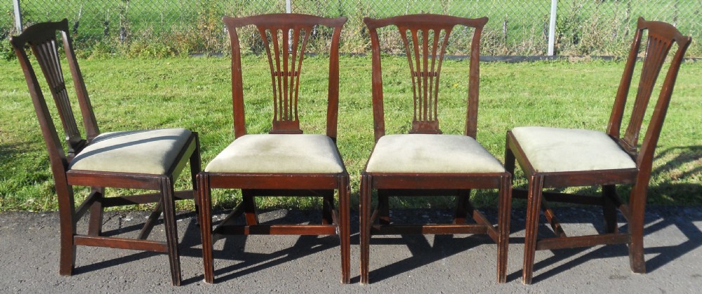 A set of four Georgian mahogany dining chairs featuring vertical pierced back splats, straight reeded front legs, and padded light-coloured seats. View III