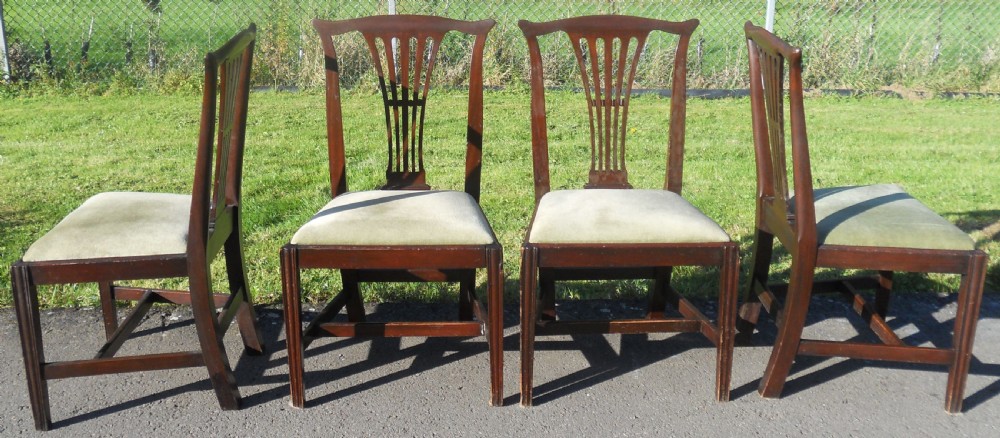 A set of four Georgian mahogany dining chairs featuring vertical pierced back splats, straight reeded front legs, and padded light-coloured seats. View IV