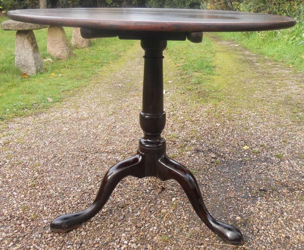 A Georgian mahogany supper table with a polished circular top, turned pedestal stem, and three cabriole legs terminating in pad feet. View IV
