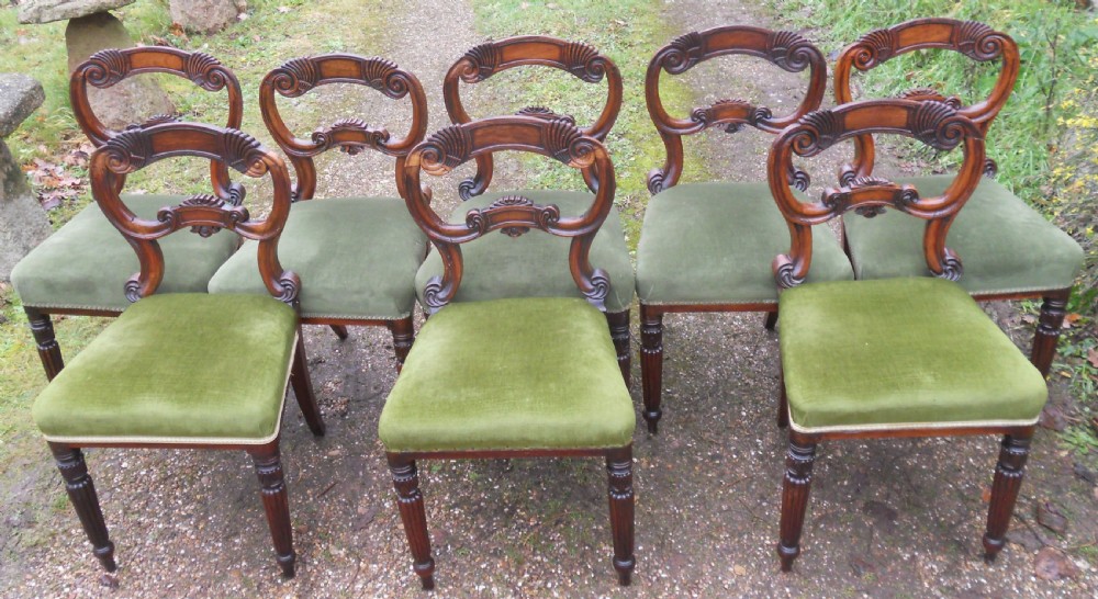 A set of eight dark rosewood Regency dining chairs featuring carved crest rails, turned front legs, and green velvet upholstered seats. View II