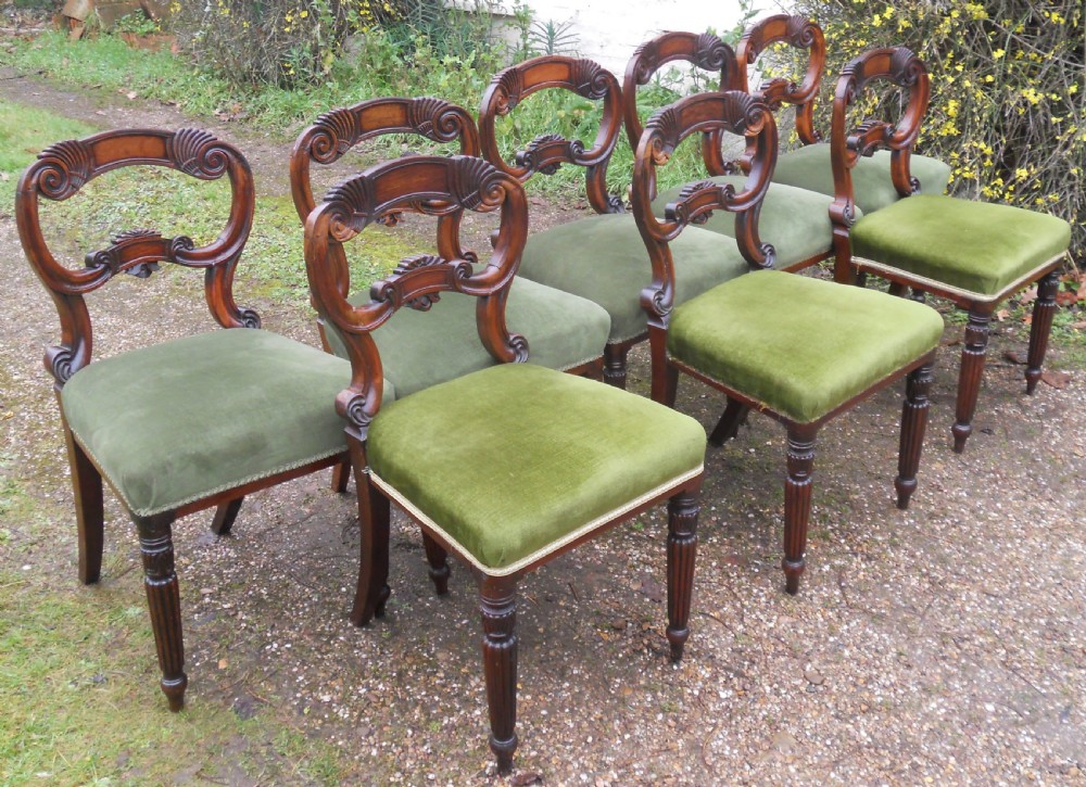 A set of eight dark rosewood Regency dining chairs featuring carved crest rails, turned front legs, and green velvet upholstered seats. View III