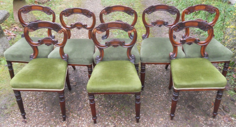A set of eight dark rosewood Regency dining chairs featuring carved crest rails, turned front legs, and green velvet upholstered seats. View IV