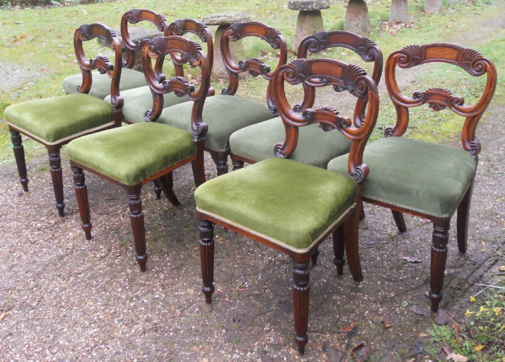 A set of eight dark rosewood Regency dining chairs featuring carved crest rails, turned front legs, and green velvet upholstered seats. View V
