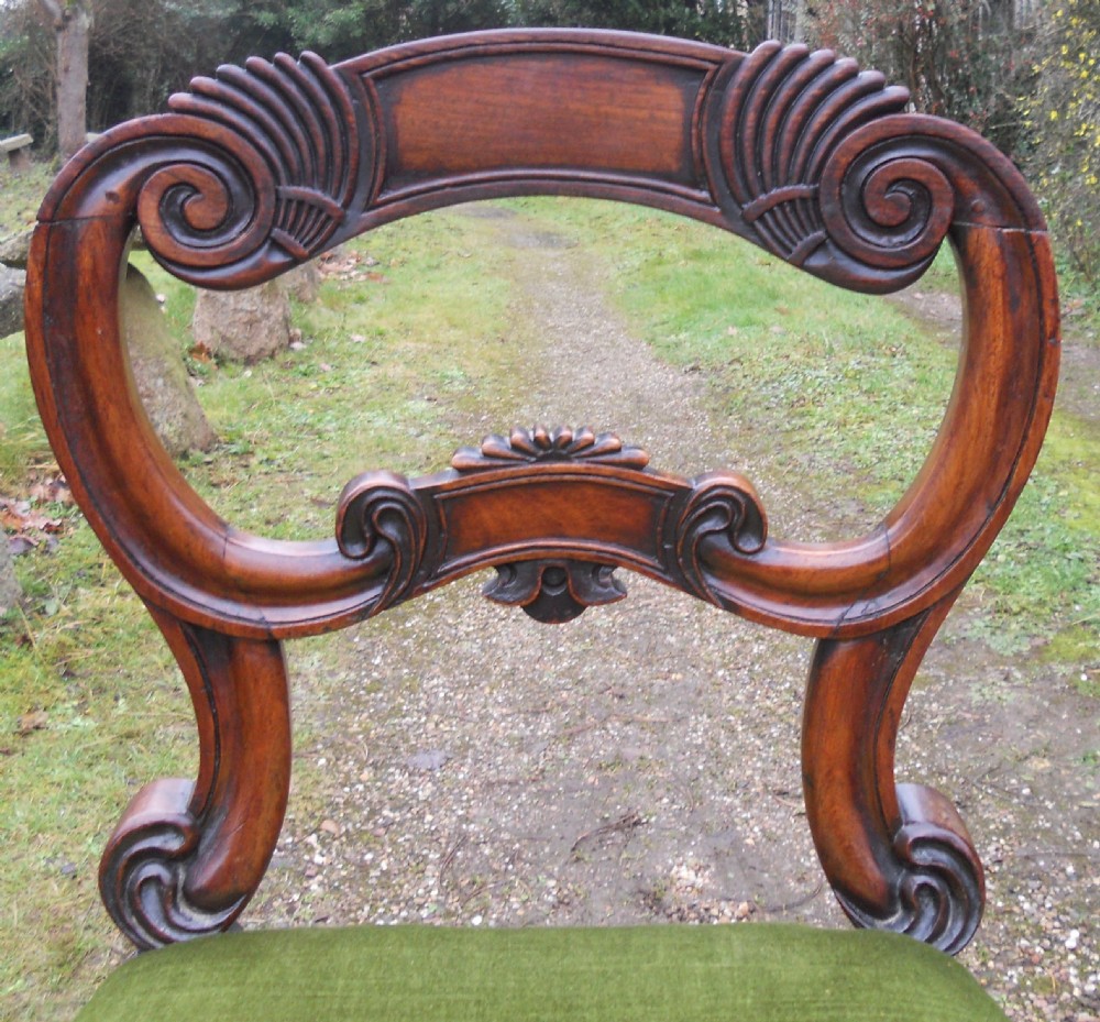 A set of eight dark rosewood Regency dining chairs featuring carved crest rails, turned front legs, and green velvet upholstered seats. View VI