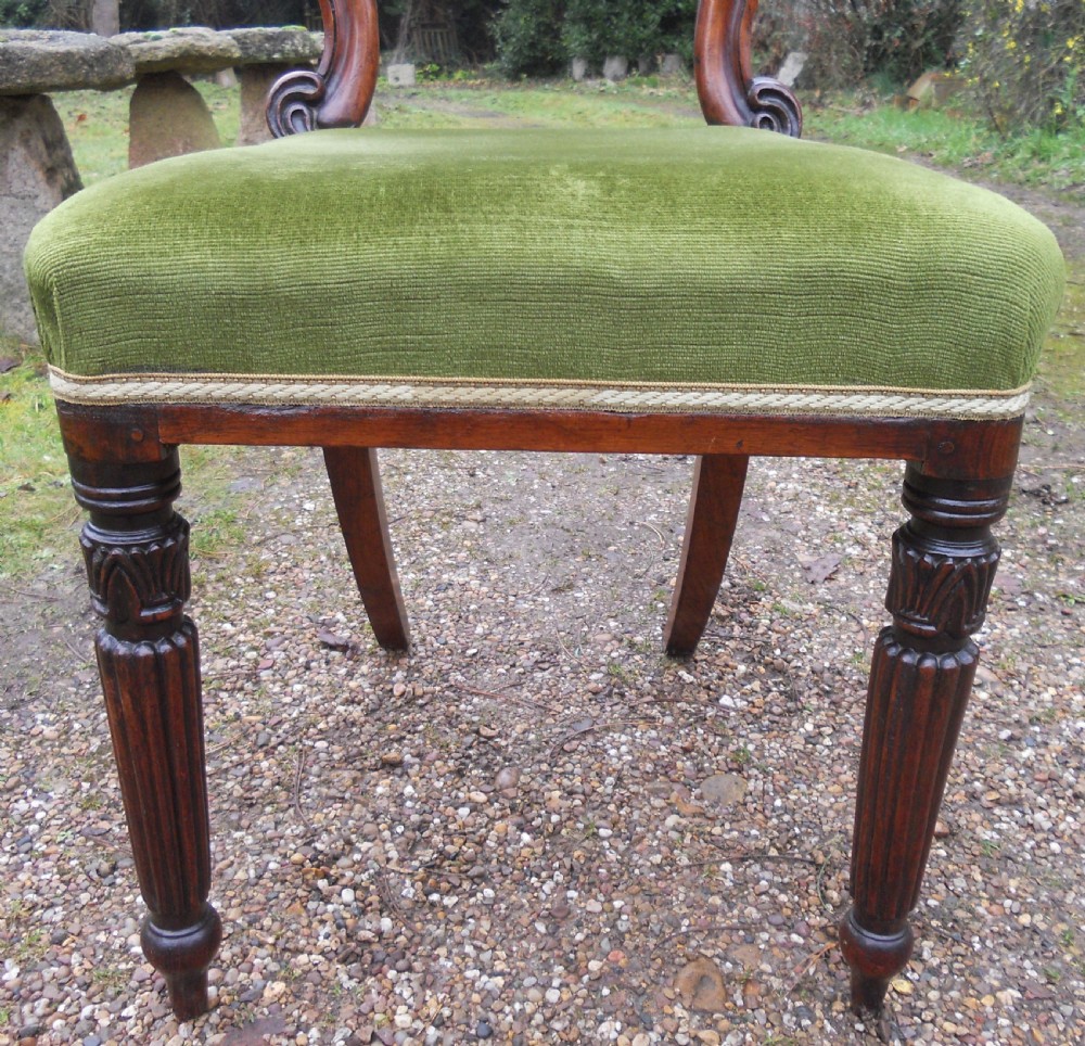 A set of eight dark rosewood Regency dining chairs featuring carved crest rails, turned front legs, and green velvet upholstered seats. View VII