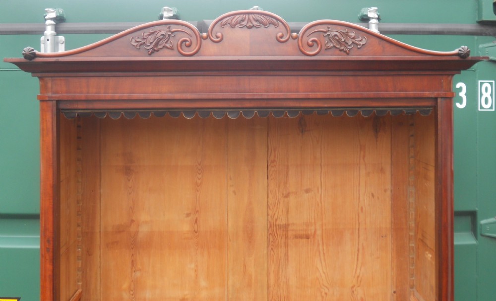 A tall Victorian mahogany open bookcase featuring a carved scroll cresting, adjustable internal shelves, and pine-panelled backing. View IV