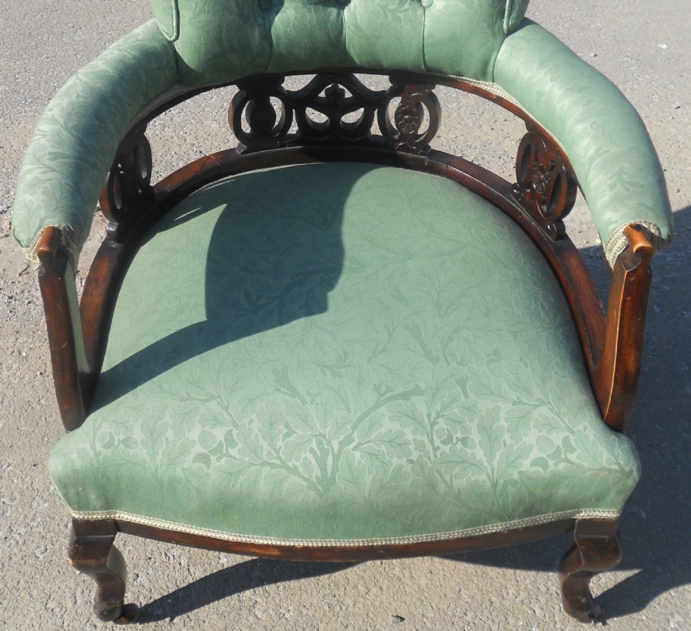 A pair of antique Art Nouveau mahogany armchairs upholstered in green patterned damask fabric with carved wooden frames and cabriole legs. View VIII