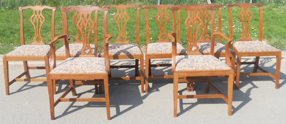 A set of eight warm brown oak Chippendale style dining chairs, comprising six side chairs and two carvers with patterned fabric drop-in seats. View II