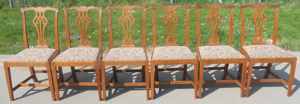 A set of eight warm brown oak Chippendale style dining chairs, comprising six side chairs and two carvers with patterned fabric drop-in seats. View VI
