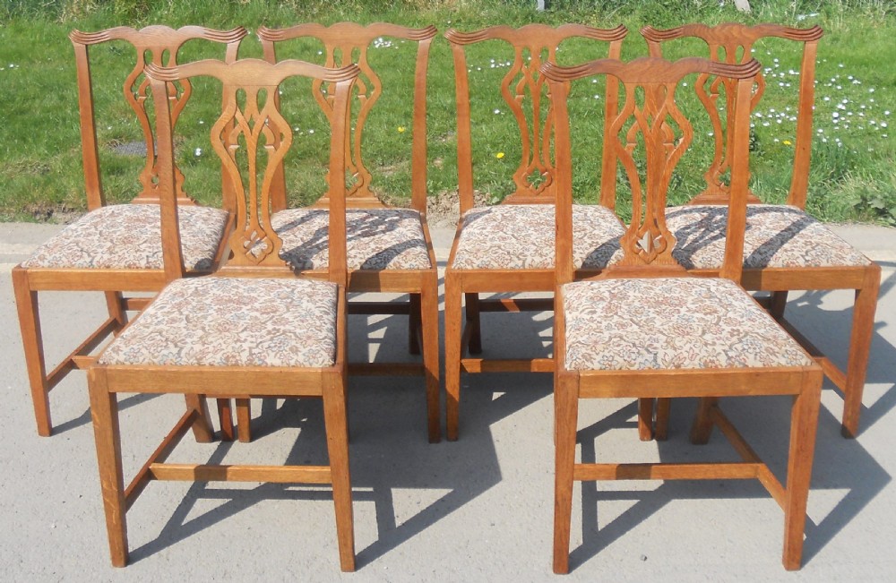 A set of eight warm brown oak Chippendale style dining chairs, comprising six side chairs and two carvers with patterned fabric drop-in seats. View XII