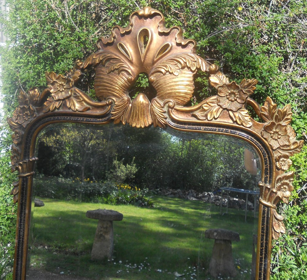 A large rectangular gold gilt wall mirror featuring an ornate shell and leaf carved crest. View VII