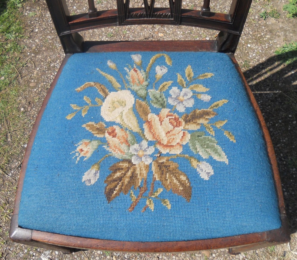 A pair of Georgian mahogany dining chairs featuring carved lattice backrests and blue needlepoint seats embroidered with floral motifs. View IV