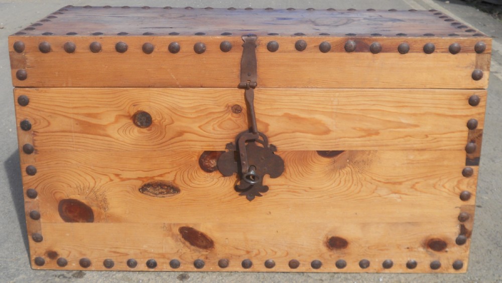 A rectangular Victorian pine wooden blanket box featuring studded iron trim along the edges, side drop handles, and an iron latch on the front. View IX