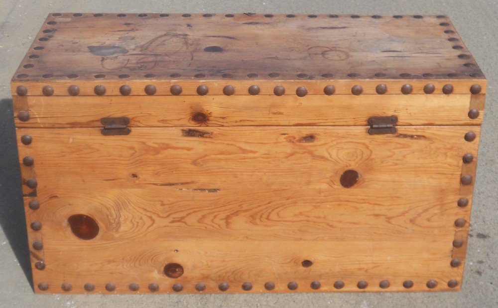 A rectangular Victorian pine wooden blanket box featuring studded iron trim along the edges, side drop handles, and an iron latch on the front. View X
