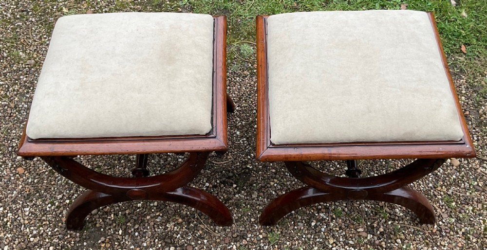 A pair of William IV mahogany x-frame stools with neutral light beige upholstered padded tops and turned central stretchers. View VI