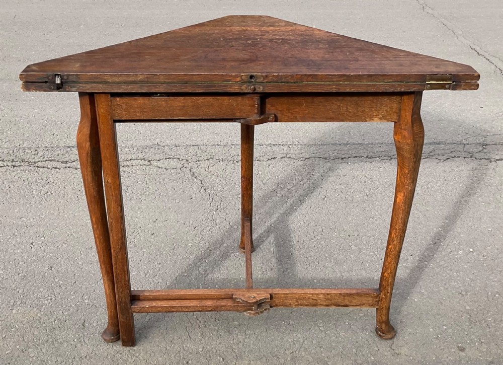 Triangular solid oak folding card table with three shaped legs and lower support stretchers. View VI