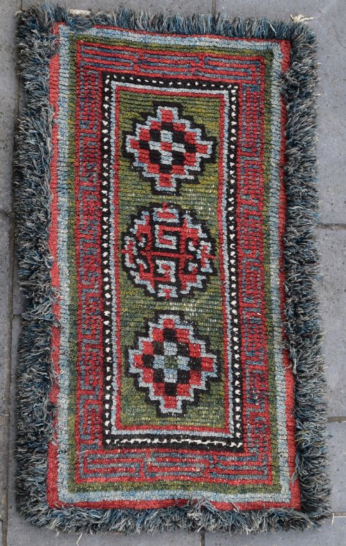 A RARE GREEN GROUND MONASTIC SEATING MAT FROM THE WANGDEN VALLEY TIBET