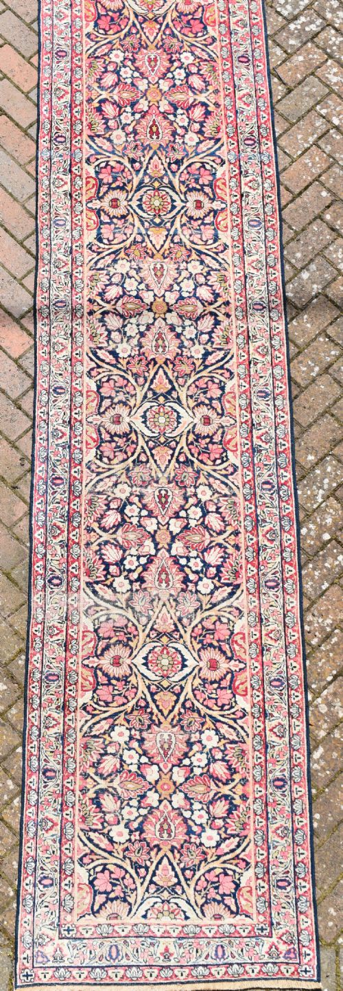 AN ANTIQUE KIRMAN RUNNER OF EXCEPTIONALLY LONG NARROW PROPORTIONS - ADDITIONAL PHOTO 1