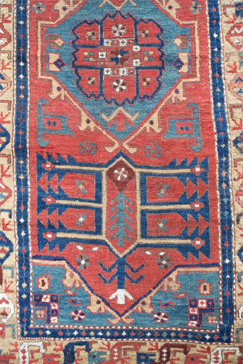 A long hand-knotted antique Heriz runner rug with geometric medallions in red, blue, turquoise, and cream tones. View II