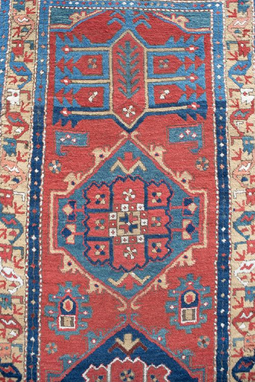 A long hand-knotted antique Heriz runner rug with geometric medallions in red, blue, turquoise, and cream tones. View III